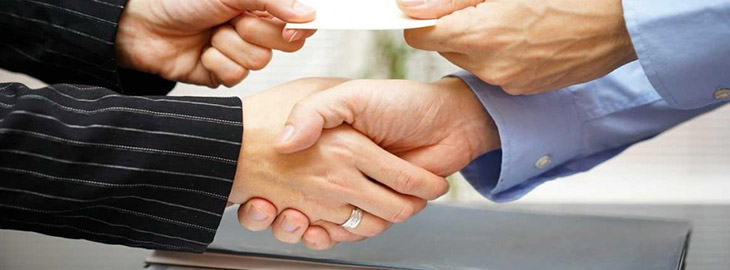 business people shaking hands and exchanging document