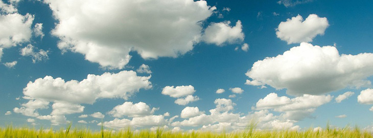 cloudy blue sky over a green meadow
