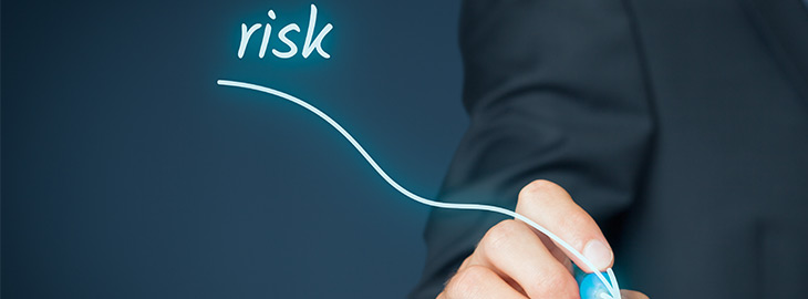businessman drawing a downward line from the word risk