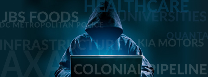 hacker on laptop with popular hacked industries such as healthcare, universities, colonial pipeline as floating text