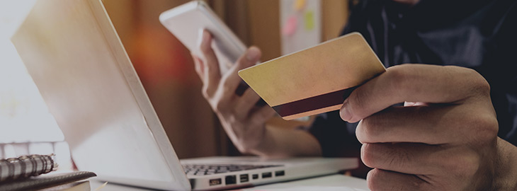 man using laptop and holding credit card with social media while online shopping