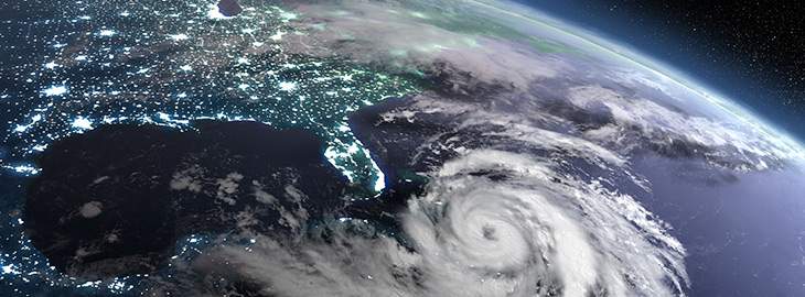Earth at night from orbit with city lights and huge hurricane
